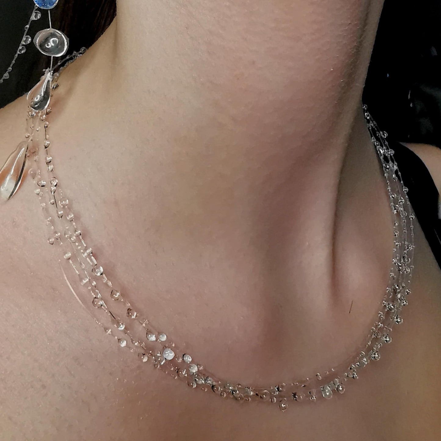 A delicate cascade of shimmering droplets, the Petit Droplet Chain captures the ethereal beauty of soft rain glistening in the light. Featuring five strands of crystal-clear beads, this piece creates an enchanting illusion of water droplets floating around your neck, offering a mesmerizing and elegant touch to any outfit.